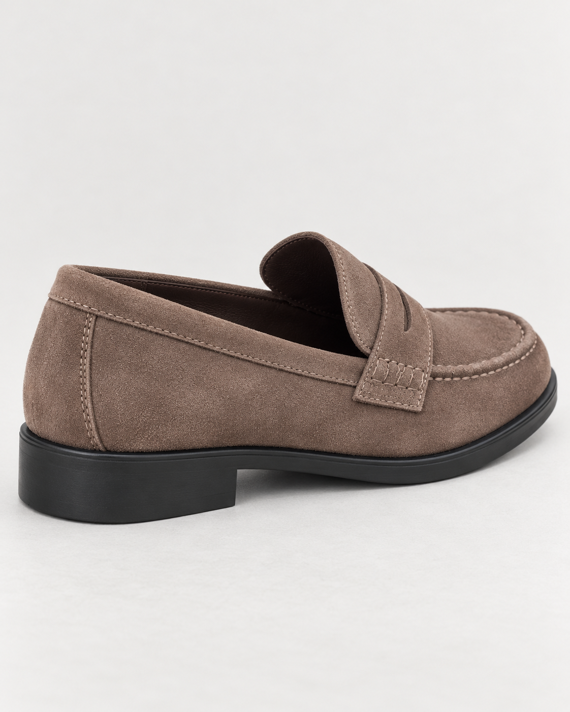 Two women wearing tan penny loafers: one in a charcoal suit and the other in blue jeans.